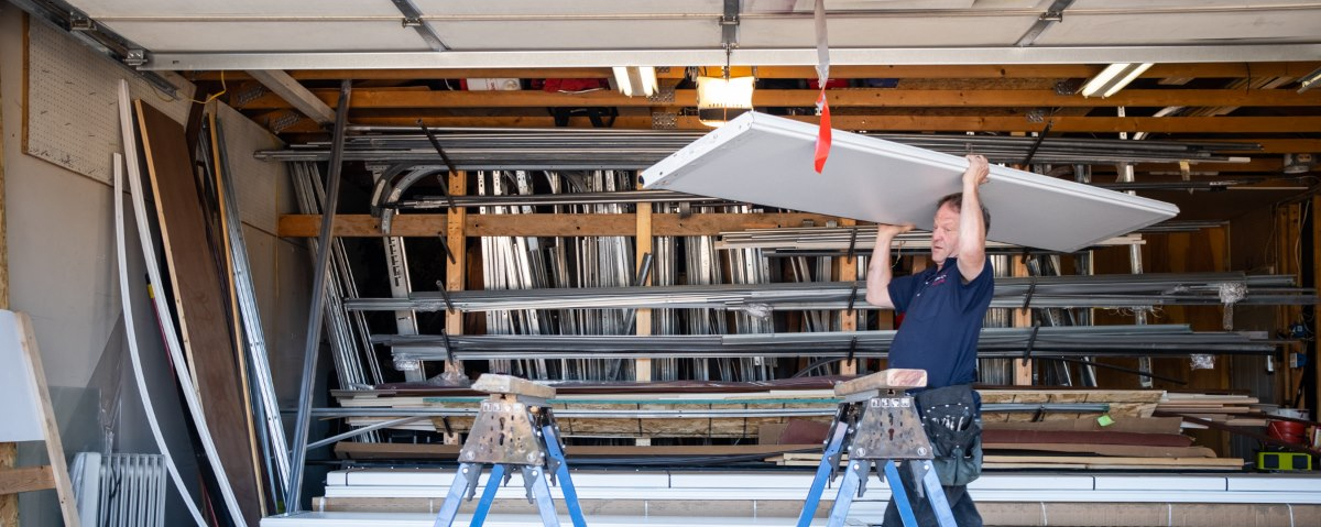 person moving a panel to a garage door